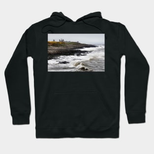 Dunstanburgh castle with rough waves battering the coast in Northumberland, UK Hoodie